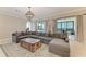 Spacious living room featuring a large sectional sofa, decorative trunk table, and bright windows at 5602 Tidewater Preserve Blvd, Bradenton, FL 34208