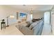 Bright living room features a large grey sofa, shiplap wall, and entertainment center with beach-themed art at 5602 Tidewater Preserve Blvd, Bradenton, FL 34208