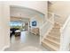 Open living room with staircase, tile flooring, shiplap accent wall, and sliding glass doors at 5602 Tidewater Preserve Blvd, Bradenton, FL 34208