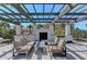 Cozy outdoor seating area with an outdoor fireplace, grill, and scenic pergola at 5602 Tidewater Preserve Blvd, Bradenton, FL 34208