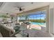 Inviting screened patio area with comfortable seating, ceiling fans, outdoor kitchen, and a sparkling pool overlooking lush greenery at 5602 Tidewater Preserve Blvd, Bradenton, FL 34208