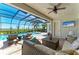 Comfortable lounge area on screened patio with ceiling fan, and view of the refreshing swimming pool and tranquil views beyond at 5602 Tidewater Preserve Blvd, Bradenton, FL 34208