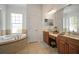 Bright bathroom boasts double sinks, a soaking tub, and natural light from the large, frosted window at 5715 Sea Trout Pl, Apollo Beach, FL 33572