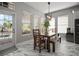Open dining area featuring a modern light fixture, bright windows, and easy access to the outdoor pool area at 5715 Sea Trout Pl, Apollo Beach, FL 33572