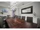 Stately dining room showcasing a rustic table, modern light fixtures and a large framed mirror at 5715 Sea Trout Pl, Apollo Beach, FL 33572