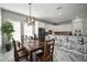 Open dining area adjacent to the kitchen featuring a modern chandelier and views of the backyard at 5715 Sea Trout Pl, Apollo Beach, FL 33572