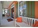 Inviting front porch features a white bench, colorful accents, and green shutters at 5715 Sea Trout Pl, Apollo Beach, FL 33572