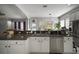 Bright kitchen featuring stainless steel appliances, dark countertops, and a seamless design with the living room at 5715 Sea Trout Pl, Apollo Beach, FL 33572