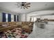 Comfortable living room flows into kitchen and dining area, with a sectional sofa and bright area rug at 5715 Sea Trout Pl, Apollo Beach, FL 33572