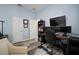 Comfortable home office with triple monitors, wood desk, and a cozy chair at 5715 Sea Trout Pl, Apollo Beach, FL 33572