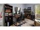 Home office with triple monitors, mini-fridge, wood desk, and comfortable seating at 5715 Sea Trout Pl, Apollo Beach, FL 33572