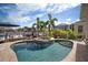 Beautiful backyard featuring a pool, hot tub, and comfortable lounge seating, surrounded by palm trees at 5715 Sea Trout Pl, Apollo Beach, FL 33572