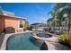 Relaxing backyard oasis with a sparkling pool, spa, outdoor seating, and lush tropical landscaping at 5715 Sea Trout Pl, Apollo Beach, FL 33572