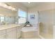Bright bathroom features a soaking tub, walk-in shower, and double vanity with modern fixtures at 5822 Title Row Dr, Bradenton, FL 34210