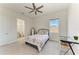 Cozy bedroom with a floral bedspread, ceiling fan, and desk with a window view at 5822 Title Row Dr, Bradenton, FL 34210