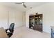 Bright, airy bedroom featuring neutral walls and carpet, plus a ceiling fan and dark wood bookshelf at 5822 Title Row Dr, Bradenton, FL 34210