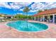 Sparkling community pool surrounded by a brick patio, lounge chairs, and lush landscaping for relaxation at 5822 Title Row Dr, Bradenton, FL 34210