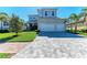 Beautiful home with a pristine lawn, mature palm trees, and an expansive driveway leading to a spacious three-car garage at 5822 Title Row Dr, Bradenton, FL 34210