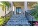 Inviting entryway showcasing stone steps, sleek metal railings, and a covered porch, enhanced by lush tropical greenery at 5822 Title Row Dr, Bradenton, FL 34210