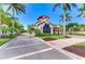 Community gate house with a tile roof, surrounded by tropical landscaping along a paved road at 5822 Title Row Dr, Bradenton, FL 34210