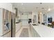 Kitchen showcasing stainless appliances, white cabinets, mosaic backsplash, and large center island at 5822 Title Row Dr, Bradenton, FL 34210