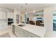 Open kitchen with white cabinets, pendant lighting, and a view into the spacious living area at 5822 Title Row Dr, Bradenton, FL 34210