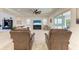 Well-lit living area featuring a blend of comfortable seating and clear access to an outdoor patio with serene water views at 5822 Title Row Dr, Bradenton, FL 34210
