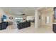 Spacious living room with tile floors and a comfortable seating arrangement, seamlessly connecting to the kitchen and outdoor space at 5822 Title Row Dr, Bradenton, FL 34210