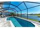 Sparkling screened-in pool with a spa offers stunning views of the community lake and manicured landscaping at 5822 Title Row Dr, Bradenton, FL 34210