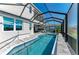 The covered, screened-in pool and spa features access to an outdoor kitchen and dining area at 5822 Title Row Dr, Bradenton, FL 34210
