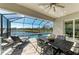 Screened-in lanai featuring an outdoor dining area and lounge chairs surrounding a beautiful pool and lake view at 5822 Title Row Dr, Bradenton, FL 34210