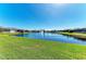 Scenic water view of a tranquil pond with a fountain, surrounded by lush green grass and beautiful homes at 5822 Title Row Dr, Bradenton, FL 34210