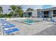 Community pool with ample lounge chairs and condo complex in the background at 6033 34Th W St # 35, Bradenton, FL 34210