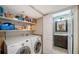Modern laundry area with washer, dryer, shelving, and utility sink next to bathroom at 6033 34Th W St # 35, Bradenton, FL 34210