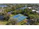 Nice aerial view of community tennis courts with lush trees, a serene pond, and ample parking at 622 Spring Lakes Blvd, Bradenton, FL 34210