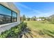 Expansive green backyard with manicured lawn and mature shrubbery offering a serene outdoor space at 622 Spring Lakes Blvd, Bradenton, FL 34210