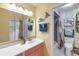 Colorful bathroom features coral vanity, blue mermaid decor, and shower-tub combination at 622 Spring Lakes Blvd, Bradenton, FL 34210