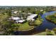 Beautiful exterior view of condos next to tranquil water, lush lawn, and mature landscaping at 622 Spring Lakes Blvd, Bradenton, FL 34210