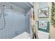 This bathroom has a blue tiled shower-tub combo with nature-inspired decor and fixtures at 622 Spring Lakes Blvd, Bradenton, FL 34210