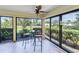 Sunroom features tiled floors and large windows that look out onto a lush yard and neighborhood at 622 Spring Lakes Blvd, Bradenton, FL 34210