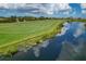 Scenic view of a meticulously maintained golf course beside a tranquil pond under a partly cloudy sky at 6519 Grand Estuary Trl # 101, Bradenton, FL 34212