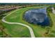 Picturesque view of golf course near a lake, with a winding cart path and residential homes at 6519 Grand Estuary Trl # 101, Bradenton, FL 34212