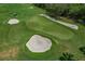 Aerial view of a meticulously maintained golf course, showcasing the green, sand traps, and surrounding landscape at 6519 Grand Estuary Trl # 101, Bradenton, FL 34212