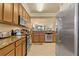 Modern kitchen with stainless steel appliances, granite counters, and an open layout to the living areas at 6519 Grand Estuary Trl # 101, Bradenton, FL 34212