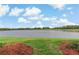Serene lake view framed by green grass and mulch, capturing the tranquil outdoor scenery at 6519 Grand Estuary Trl # 101, Bradenton, FL 34212