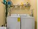 Functional laundry room featuring a full-size washer and dryer, plus an overhead shelf for supplies at 6519 Grand Estuary Trl # 101, Bradenton, FL 34212