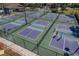 Aerial view of pickleball courts, nets, and players, all fenced in for play at 6519 Grand Estuary Trl # 101, Bradenton, FL 34212