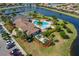 Aerial view of a community pool and tennis courts surrounded by lush landscaping and tranquil lake views at 6519 Grand Estuary Trl # 101, Bradenton, FL 34212