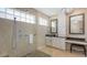Spa-like bathroom features a seamless glass shower, pebble floor, rain shower head, and dual sink vanity at 6621 The Masters Ave, Lakewood Ranch, FL 34202