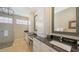 The bathroom features tiled floors, a seamless glass shower, granite countertop, and a decorative chandelier at 6621 The Masters Ave, Lakewood Ranch, FL 34202